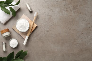 Photo of Flat lay composition with tooth powder and green leaves on grey table, space for text