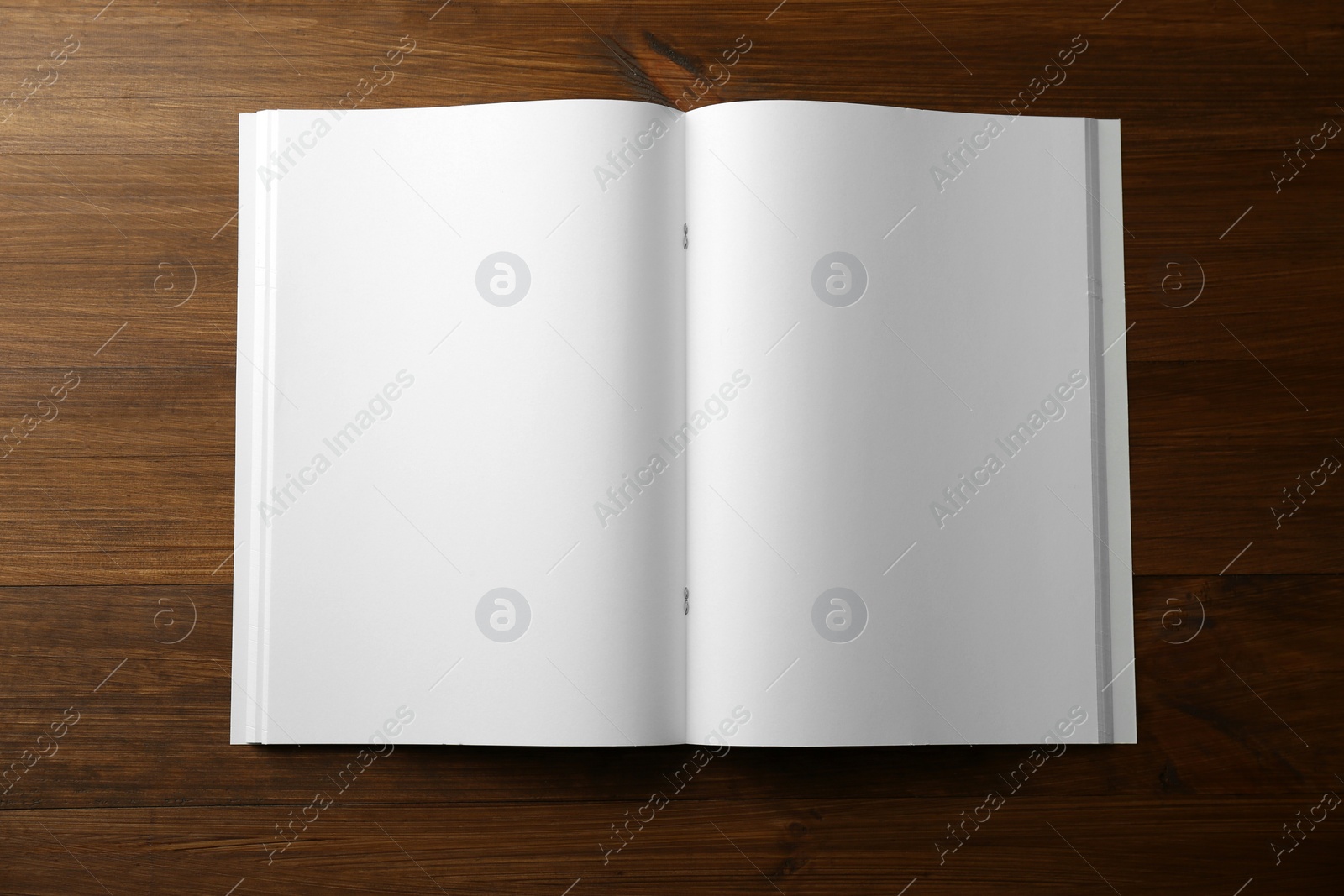 Photo of Open blank paper brochure on wooden table, top view. Mockup for design