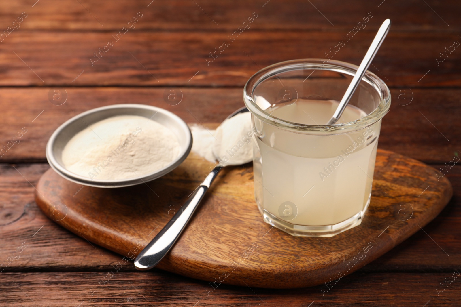 Photo of Glass of agar-agar jelly and powder on wooden table