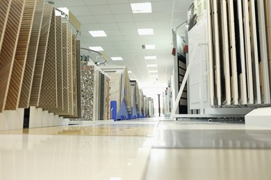 Photo of Assortment of tiles in store, low angle view. Many different samples indoors