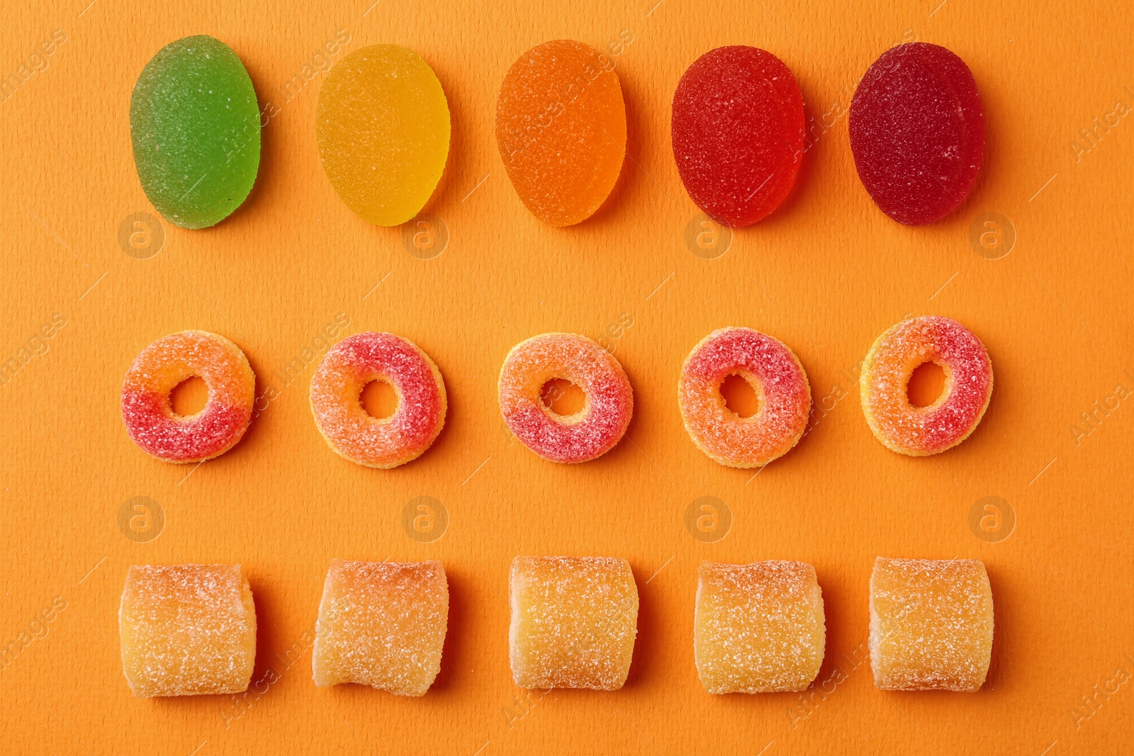 Photo of Flat lay composition with delicious jelly candies on color background