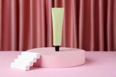 Photo of Composition with tube of hand cream on pink table, space for text