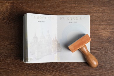 Photo of Ukraine, Lviv - September 6, 2022: Passport and visa stamp on wooden table, top view