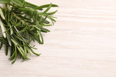 Photo of Fresh green rosemary on white wooden table, top view. Space for text