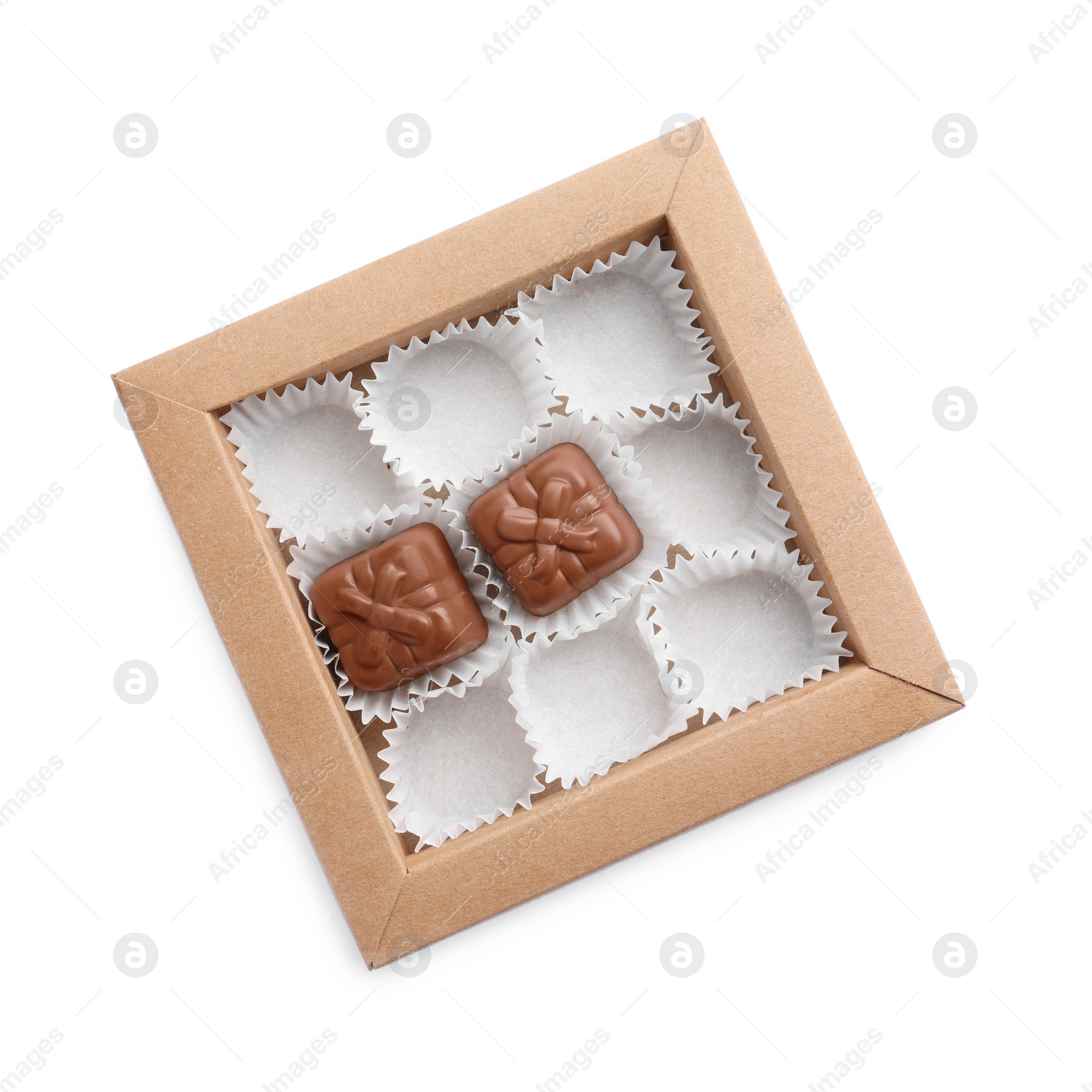 Photo of Partially empty box of chocolate candies isolated on white, top view