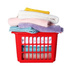 Plastic laundry basket with clean towels on white background