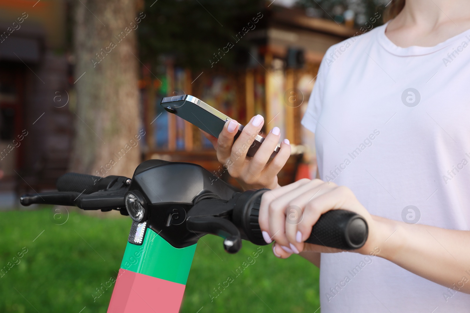 Photo of Woman using smartphone to pay and unblock electric kick scooter outdoors, closeup