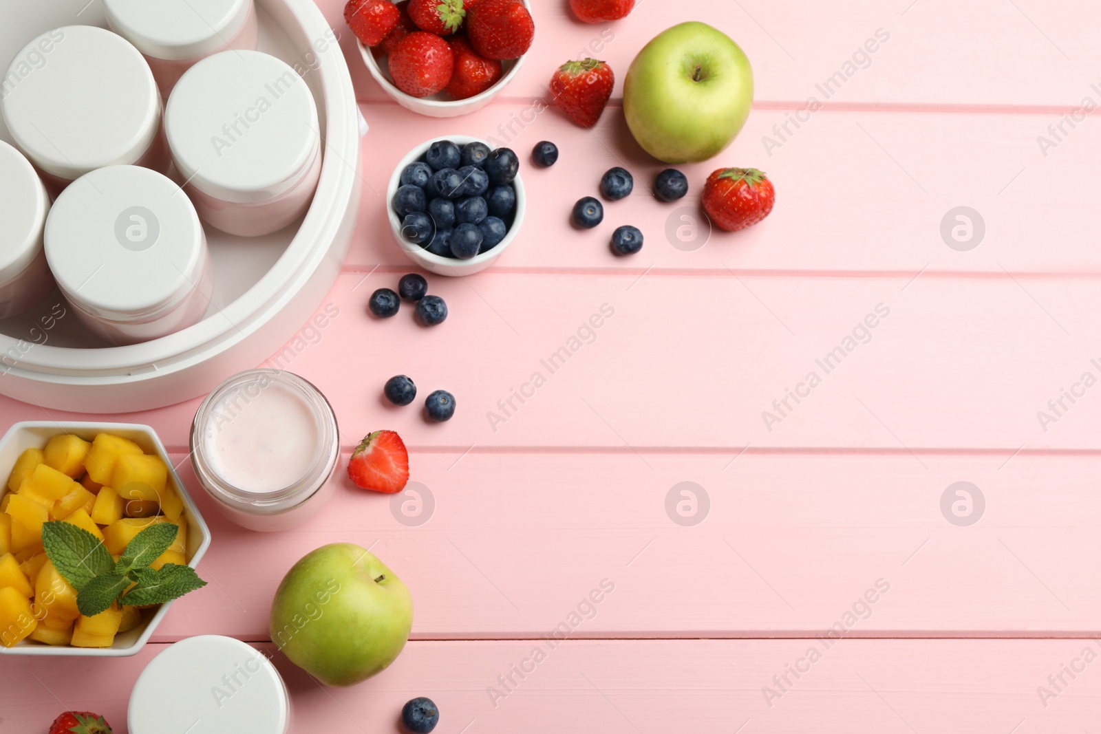 Photo of Modern yogurt maker with jars and different fruits on pink wooden table, flat lay. Space for text