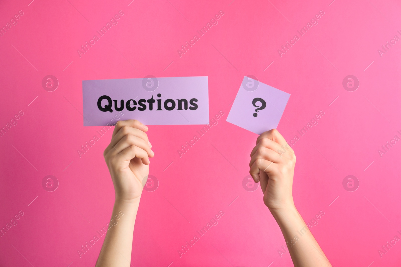 Photo of Woman holding sheets of paper with word QUESTIONS and query mark on pink background, closeup
