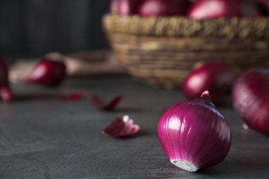 Photo of Fresh whole red onion bulb on grey table. Space for text