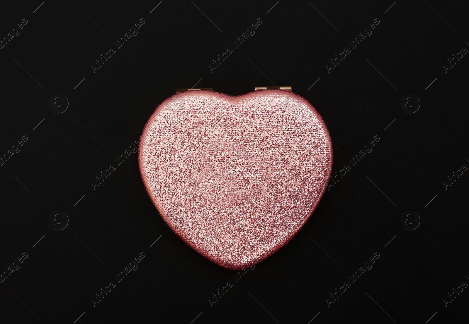 Photo of Heart shaped gold pocket mirror on black background, top view