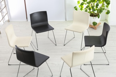 Photo of Empty chairs prepared for group psychotherapy session indoors