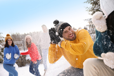 Photo of Group of friends playing snowballs outdoors. Winter vacation