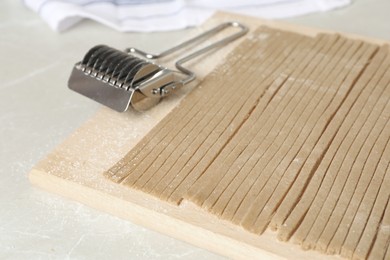 Photo of Uncooked soba (buckwheat noodles) on wooden board