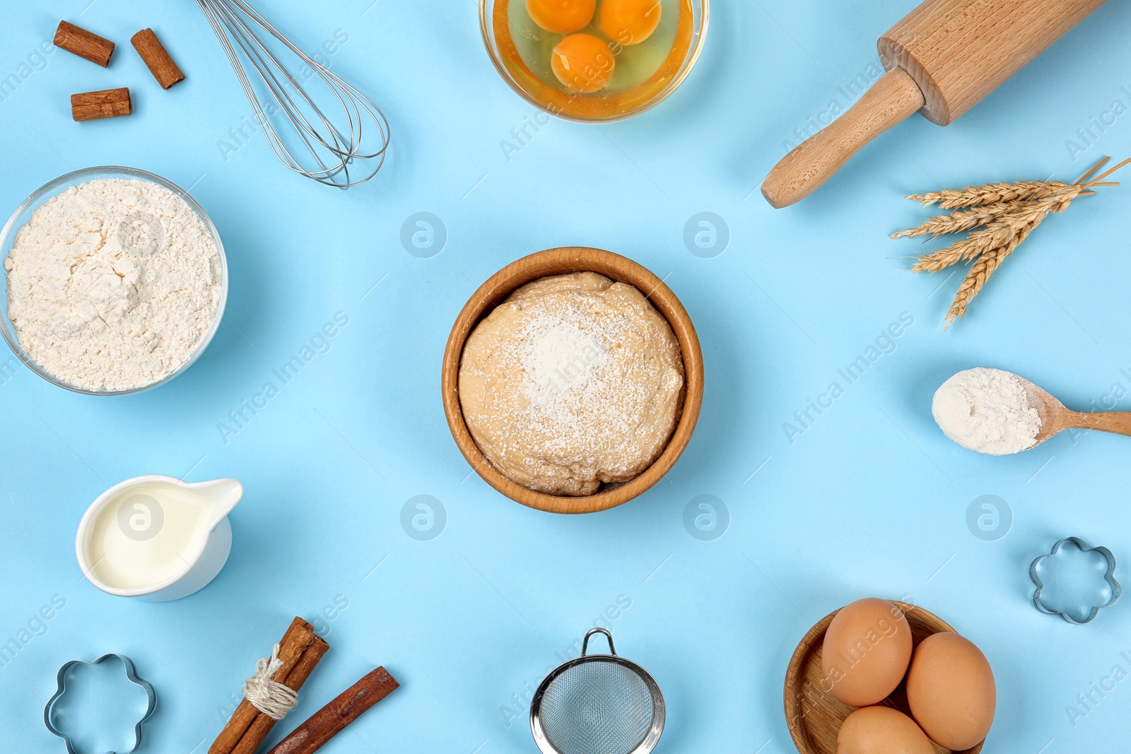 Photo of Flat lay composition with raw eggs and other ingredients on light blue background. Baking pie