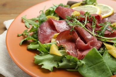 Photo of Delicious bresaola salad on table, closeup view