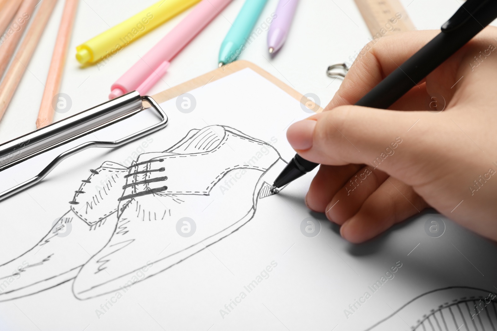 Photo of Fashion designer drawing shoes at table, closeup