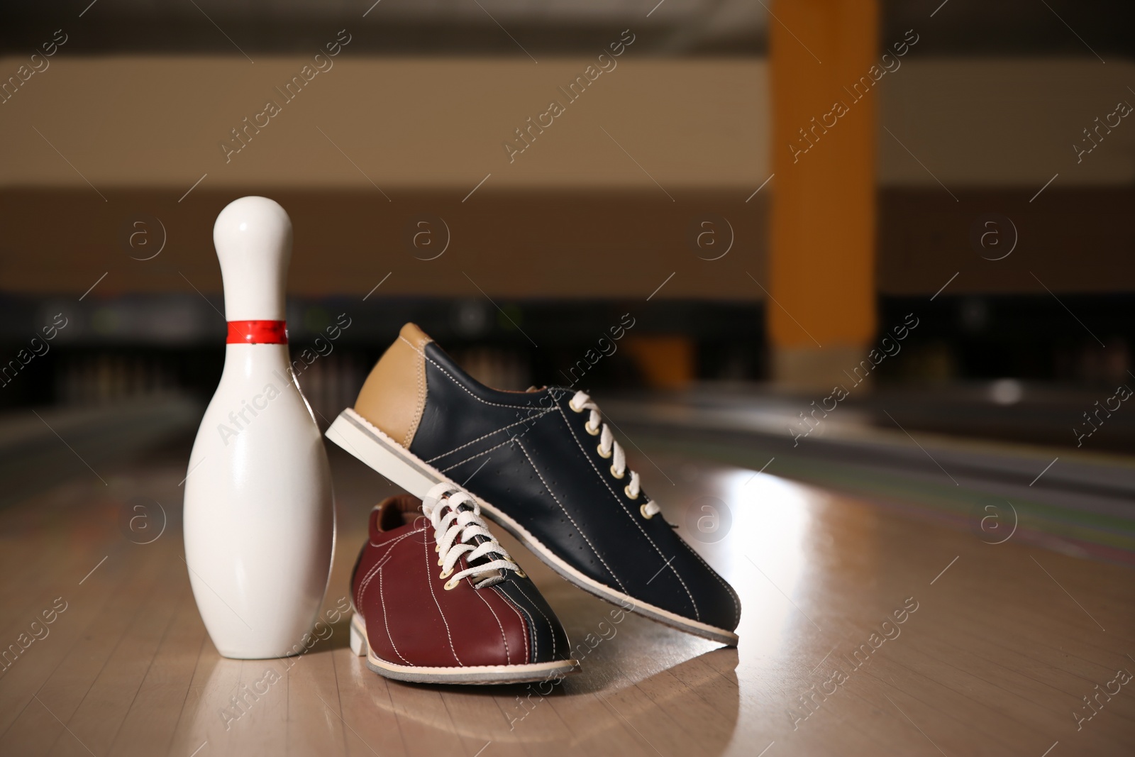 Photo of Shoes and pin on bowling lane in club. Space for text