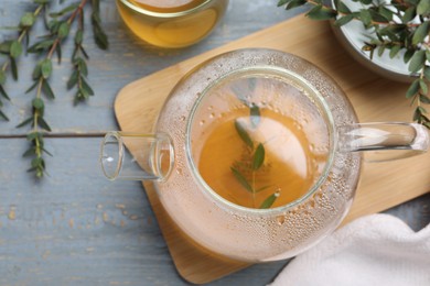 Photo of Aromatic eucalyptus tea on grey wooden table, flat lay