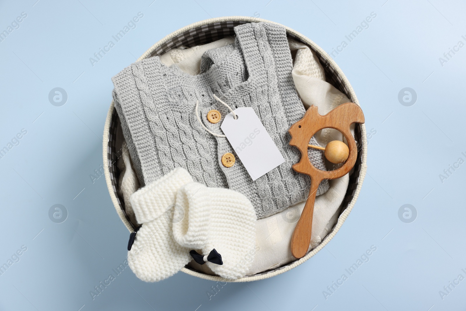 Photo of Different baby accessories and clothes in box on light blue background, top view