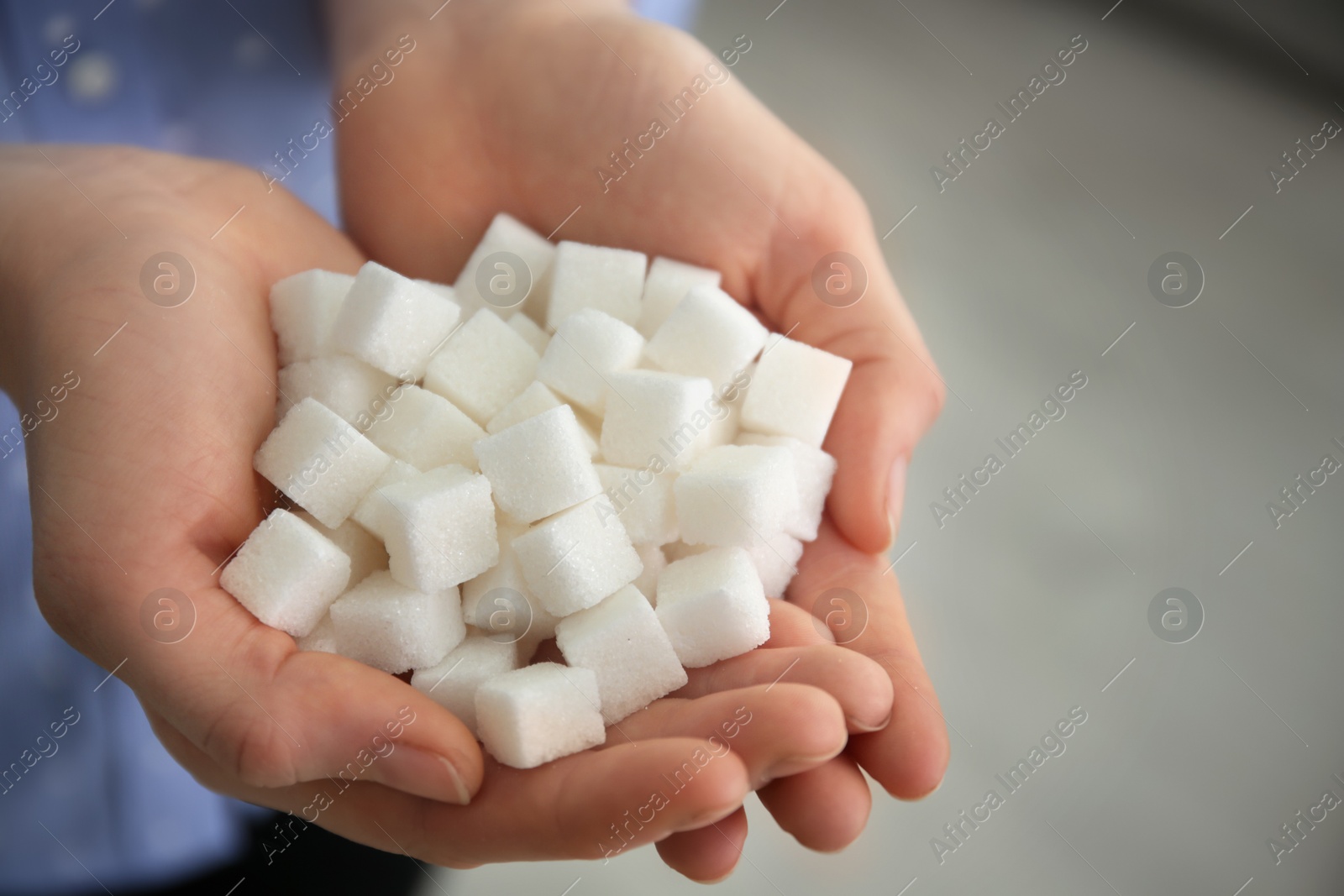 Photo of Woman holding sugar cubes, closeup