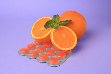 Photo of Fresh oranges, mint leaves and blister with cough drops on lilac background
