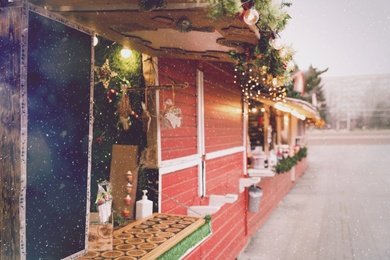 Image of Bright Christmas fair stalls with decor outdoors