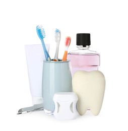 Photo of Tooth model, oral hygiene products and dentist tools on white background