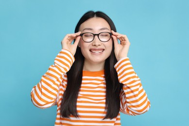 Photo of Portrait of happy woman in glasses on light blue background