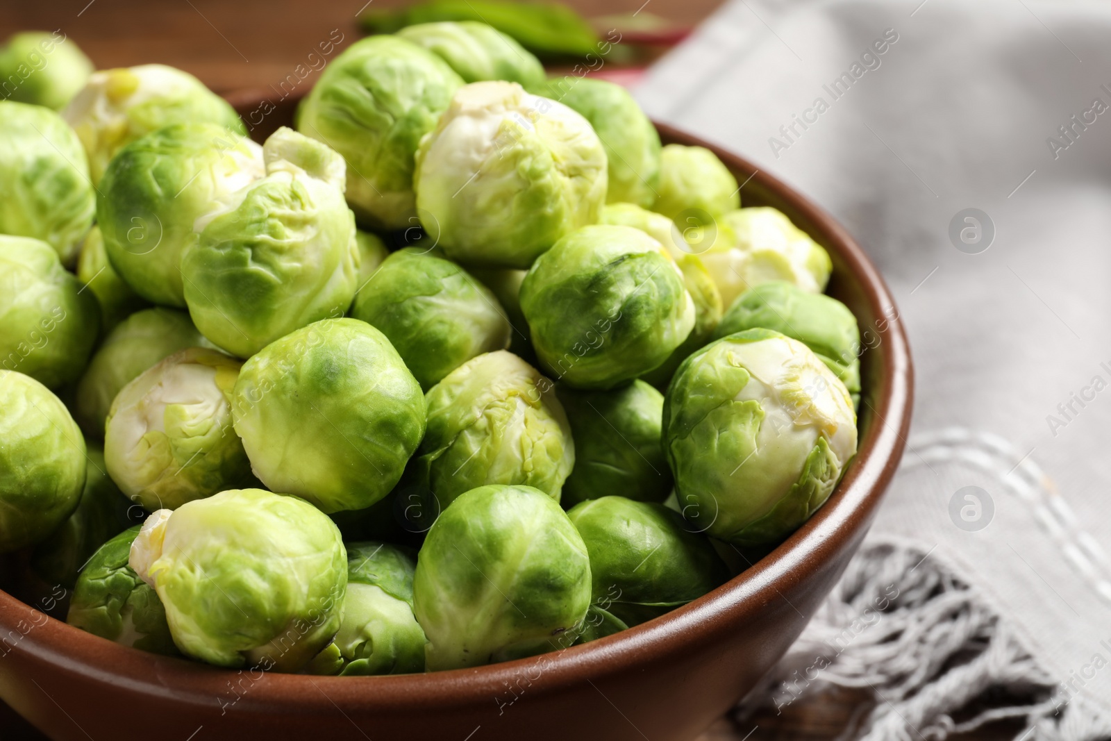 Photo of Bowl of fresh Brussels sprouts on table, closeup