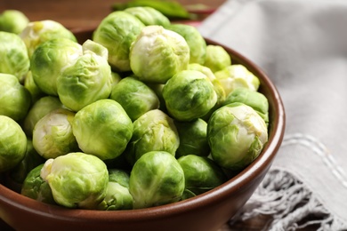 Bowl of fresh Brussels sprouts on table, closeup