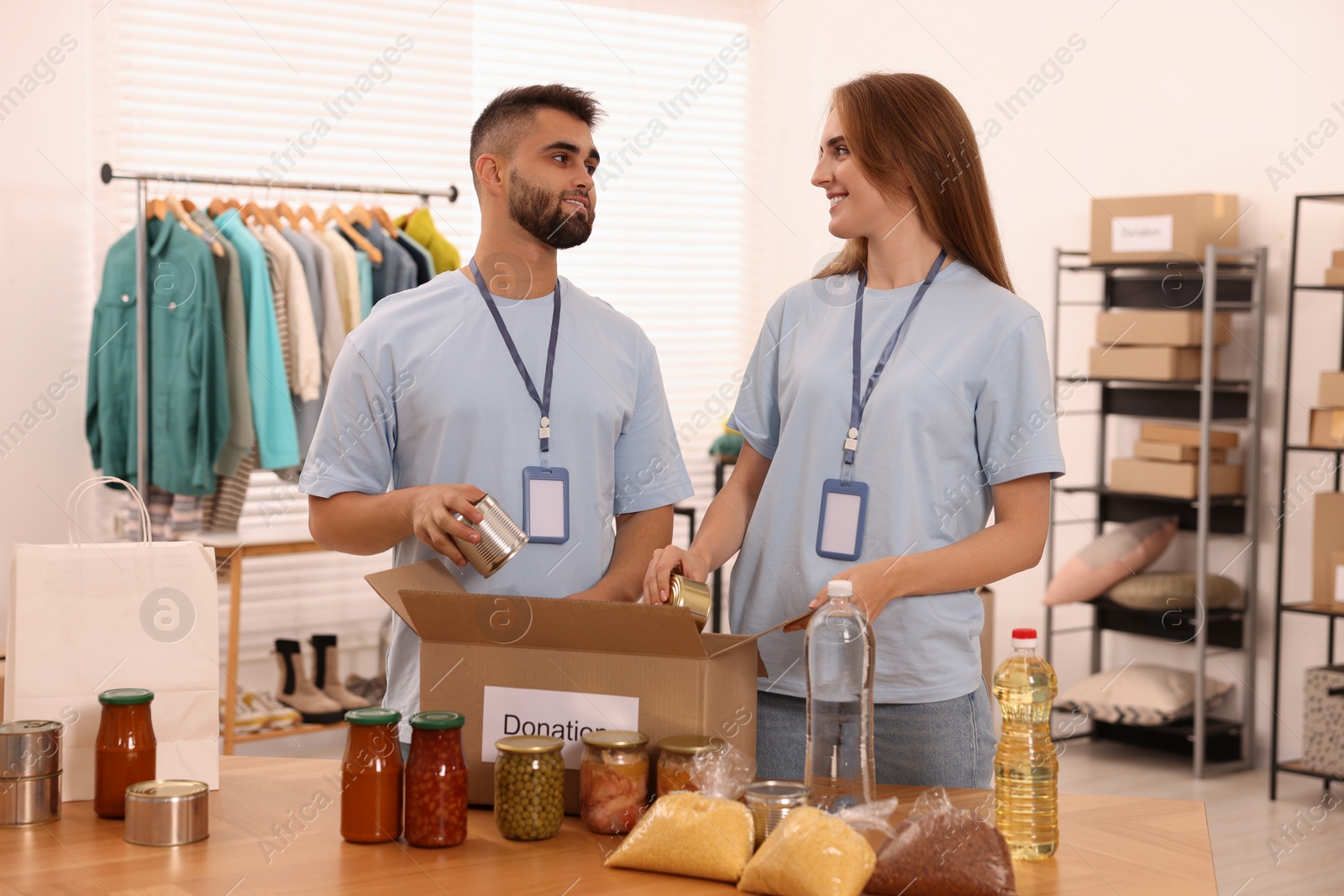 Photo of Volunteers packing food products at table in warehouse