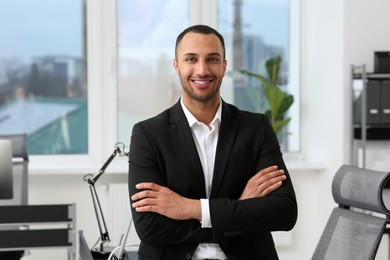 Smiling young businessman in his modern office