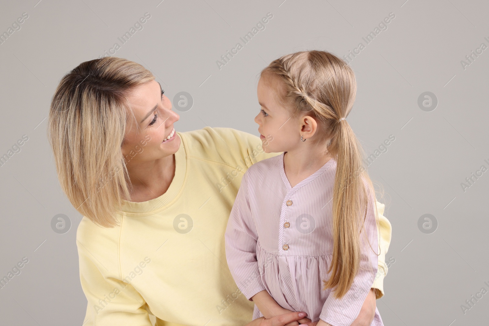 Photo of Happy mother and daughter on grey background