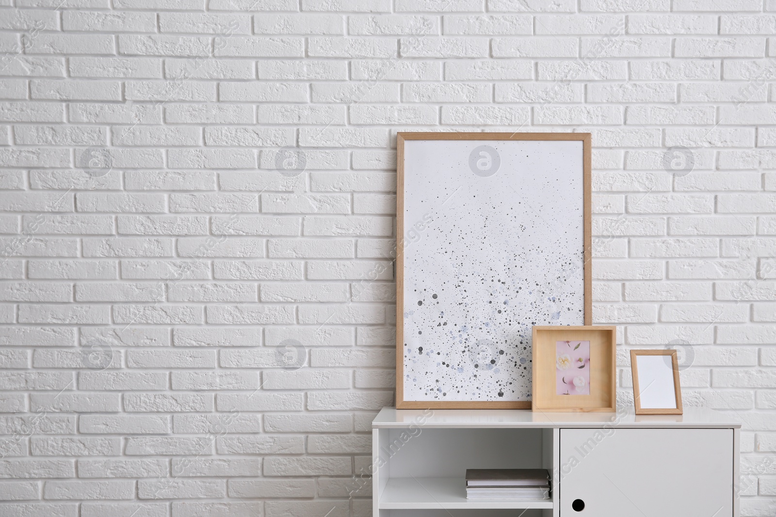 Photo of Modern white cabinet  near brick wall in room, space for text. Interior design