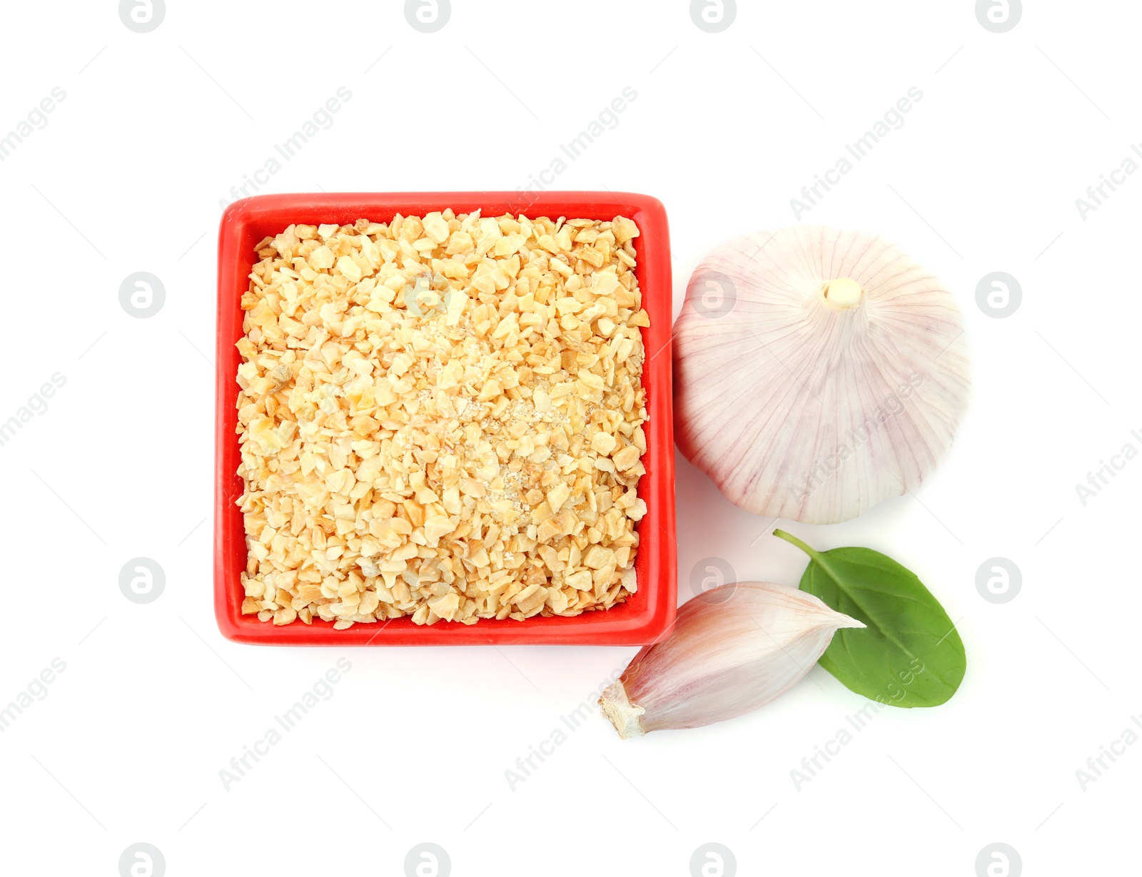 Photo of Bowl of granulated dry garlic and basil on white background, top view