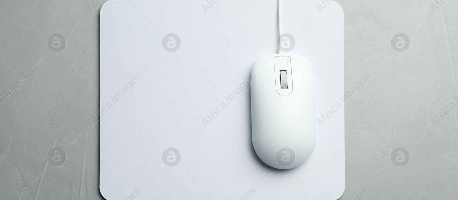 Photo of Wired computer mouse and pad on light grey background, flat lay. Space for text