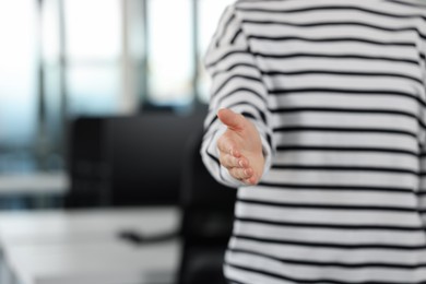 Photo of Woman welcoming and offering handshake in office, closeup. Space for text