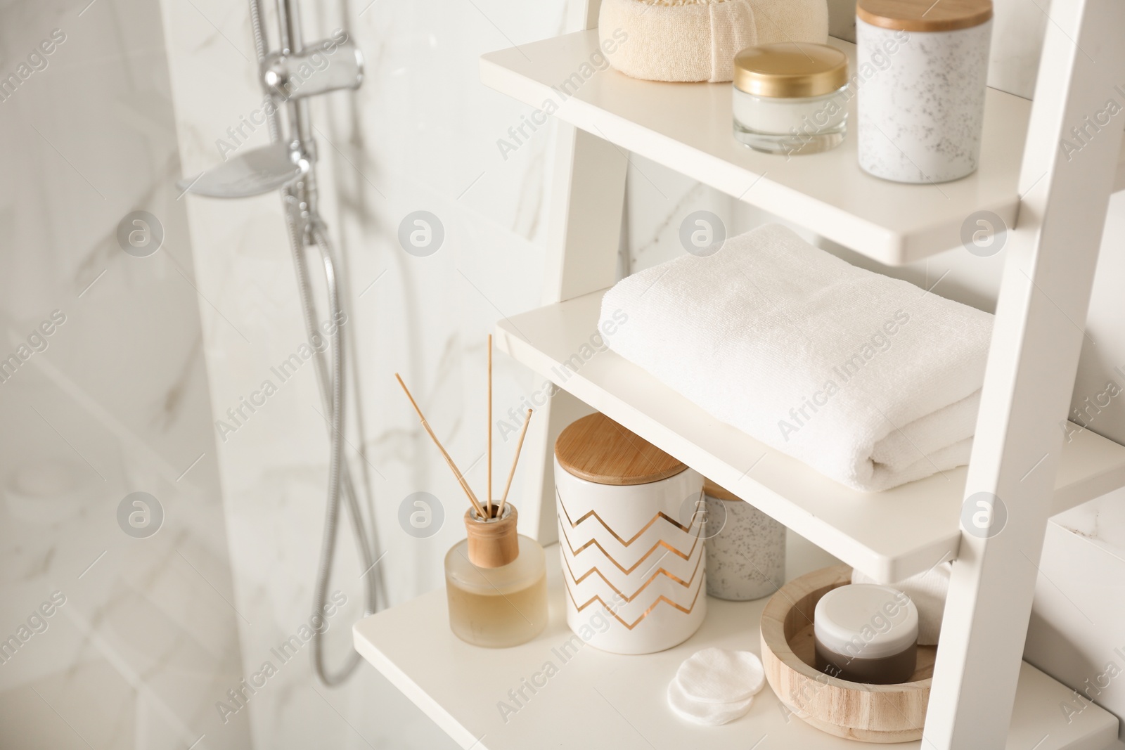 Photo of Shelving unit with different items in bathroom interior