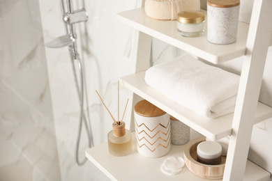 Shelving unit with different items in bathroom interior