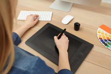 Photo of Professional designer working on graphic tablet at desk, closeup