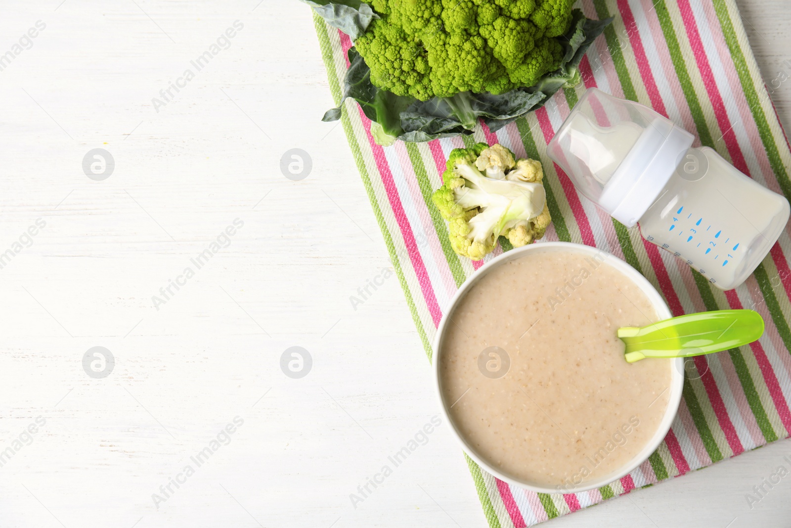 Photo of Flat lay composition with bowl of healthy baby food and space for text on wooden background