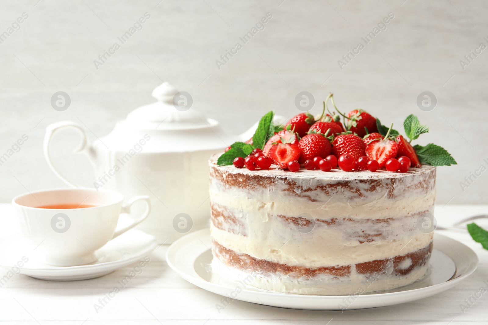 Photo of Delicious homemade cake with fresh berries served on wooden table
