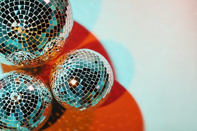 Photo of Bright shiny disco balls on color background, top view. Space for text