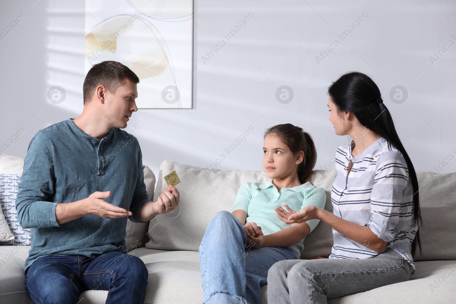 Photo of Parents talking with their teenage daughter about contraception at home. Sex education concept