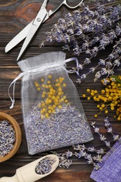 Scented sachet with mixed dried flowers and scissors on wooden table, flat lay