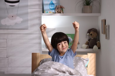 Photo of Cute little boy in bed at home
