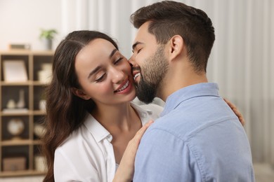 Love relationship. Happy young couple kissing at home