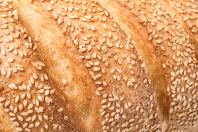 Photo of Tasty bread with sesame seeds as background, closeup