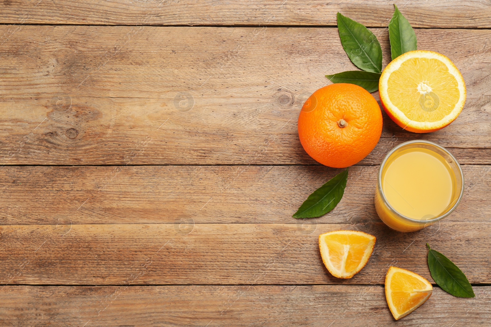 Photo of Delicious orange juice and fresh fruits on wooden table, flat lay. Space for text